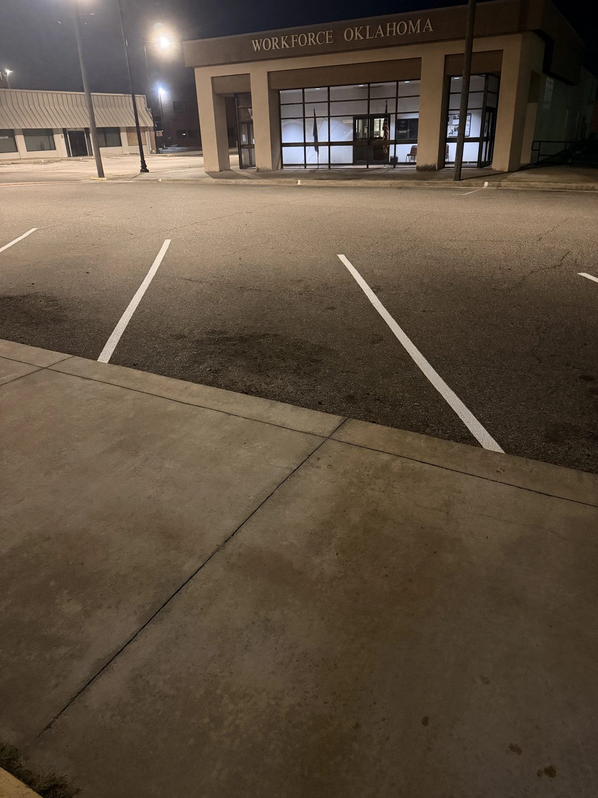 Fresh white parking lot lines at the Workforce Oklahoma office completed at night
