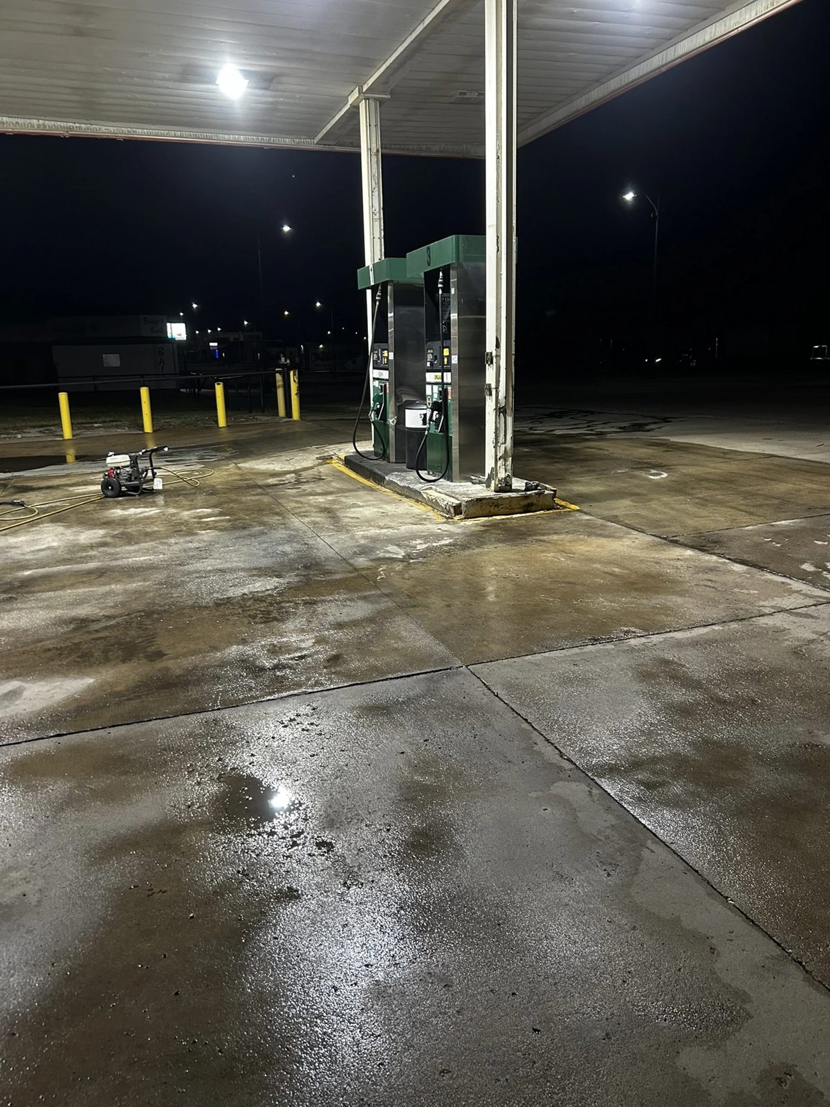 Gas pump island deep cleaned with professional pressure washing equipment